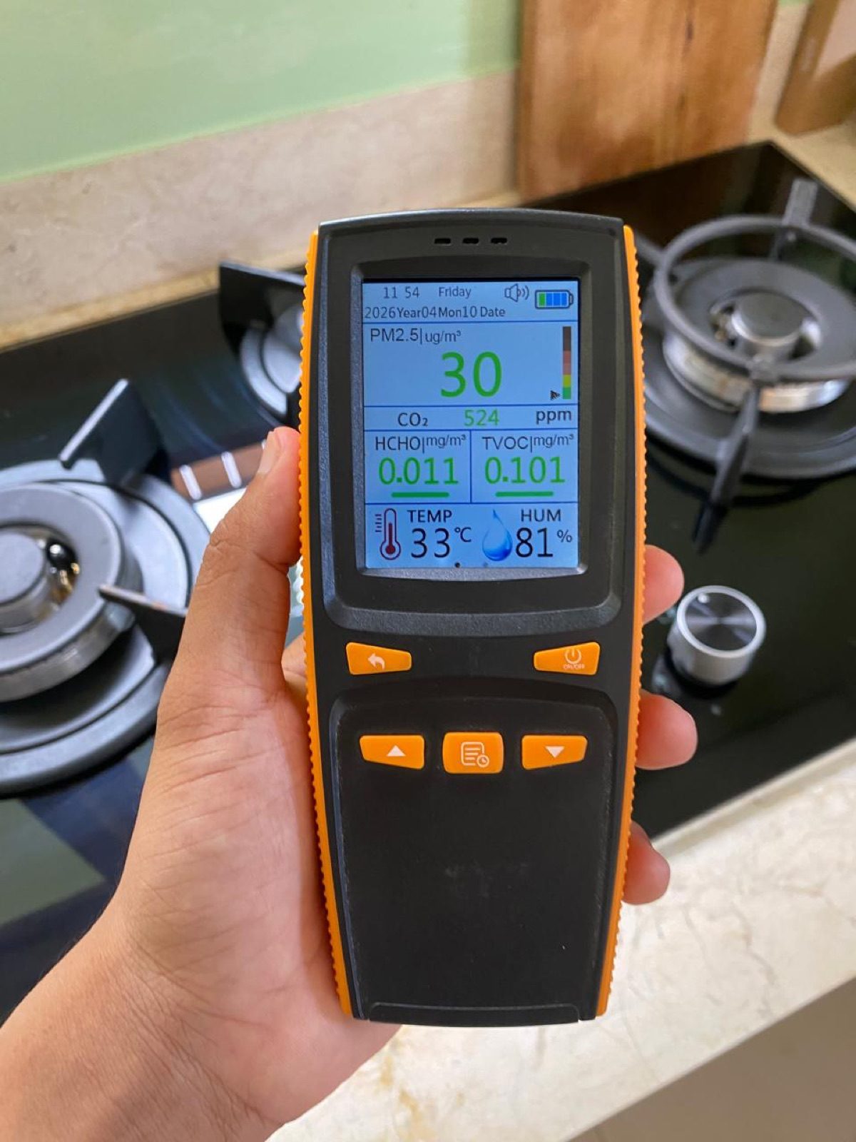 Alat ukur kualitas udara menampilkan angka PM2.5, CO₂ 524 ppm, HCHO dan TVOC di depan kompor gas dapur