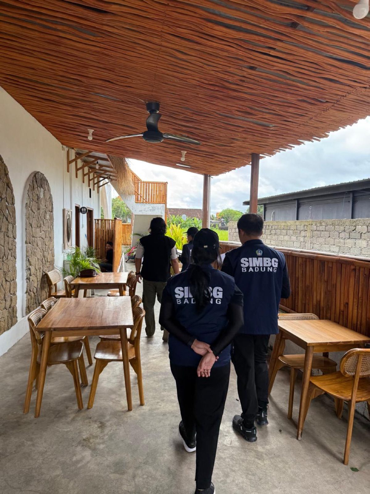 Tiga petugas SIMBG Badung berjalan menyusuri koridor kayu sebuah restoran saat pemeriksaan lapangan kelaikan fungsi